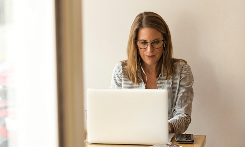 Une femme rédige sur son ordinateur portable