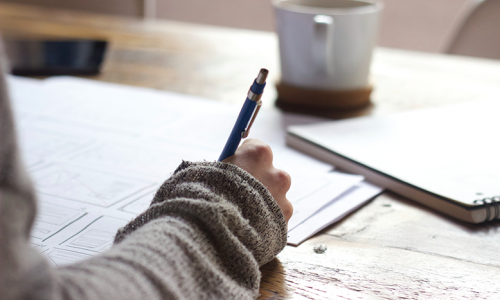 Une personne écrit avec un crayon