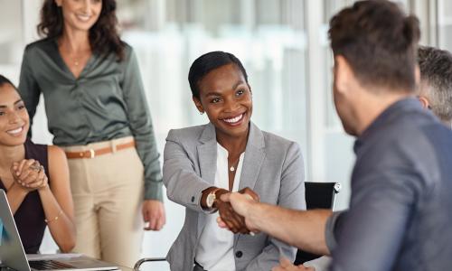 Femme et homme se serrant la main lors d'une rencontre de travail