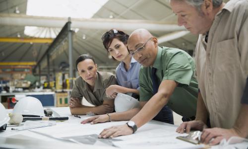 Équipe de travail penchée sur des plans