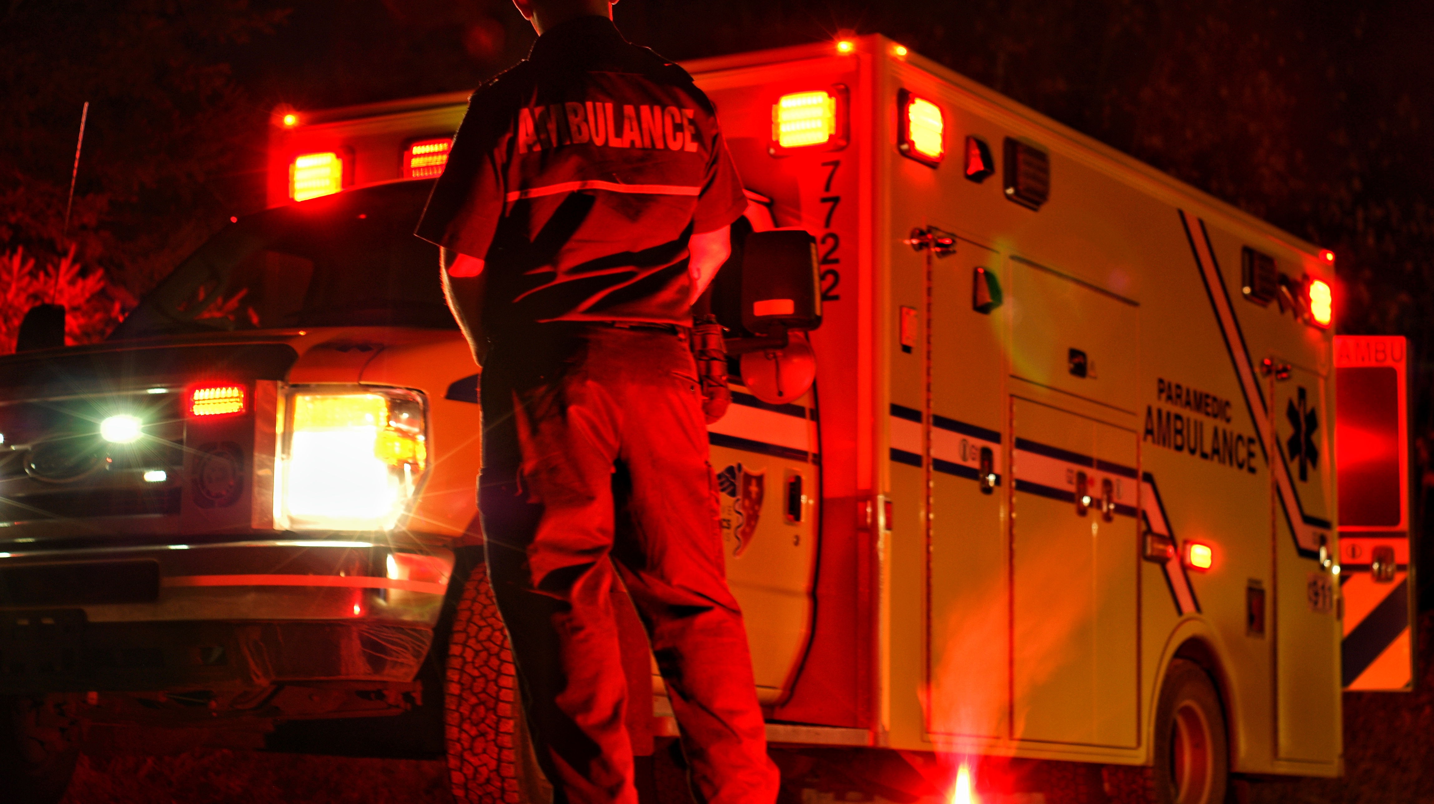 Un ambulancier de dos qui fait face à son ambulance